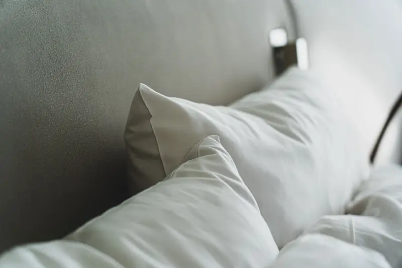 A close-up view of cozy white pillows and bedding in a modern bedroom