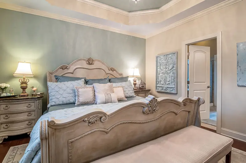 A lavishly decorated bedroom featuring classic furniture, soft lighting, and elegant decor